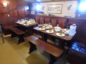 Saloon with gimbled tables, set for a meal.